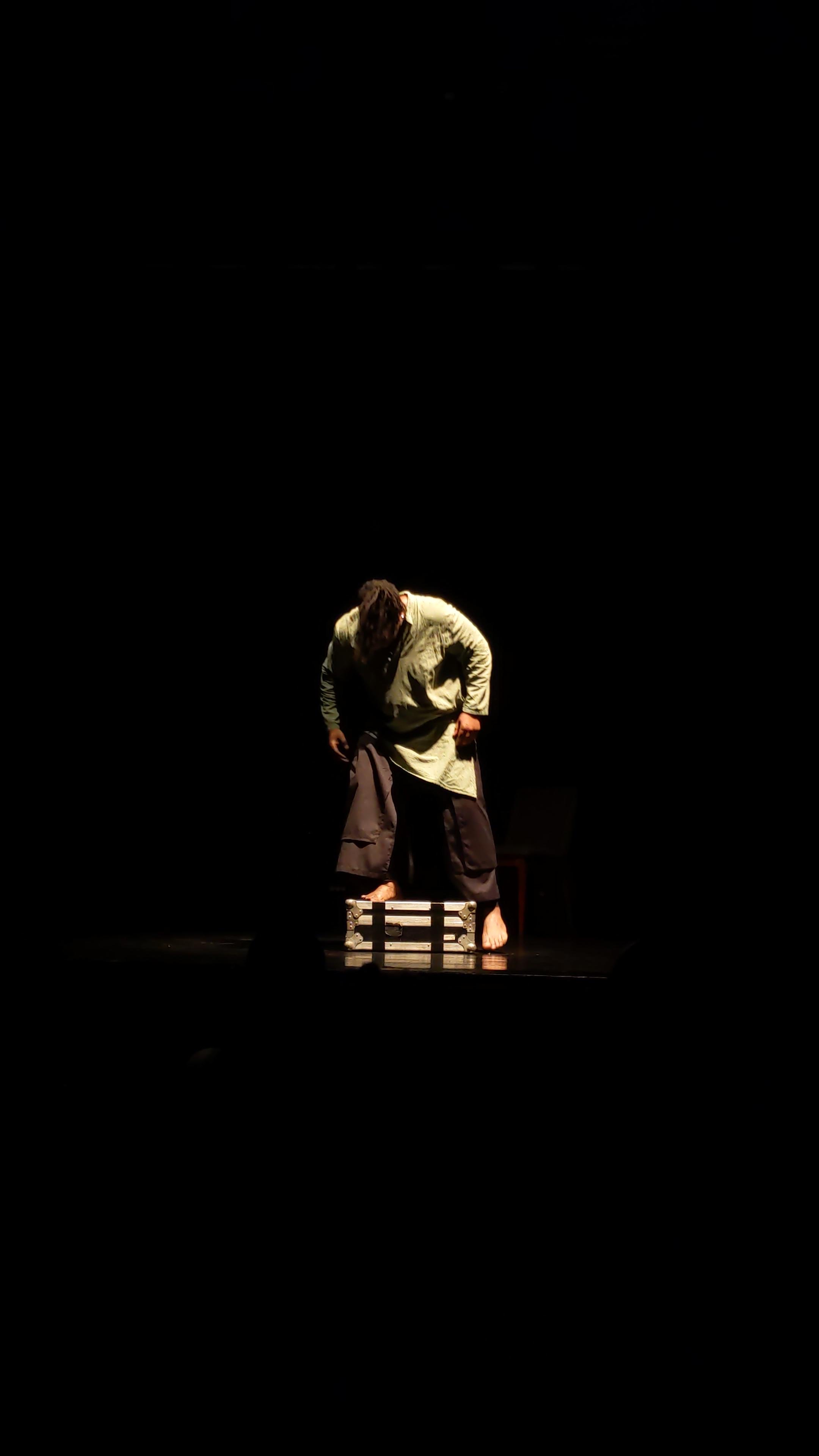 Solo sur scène, lumière sombre