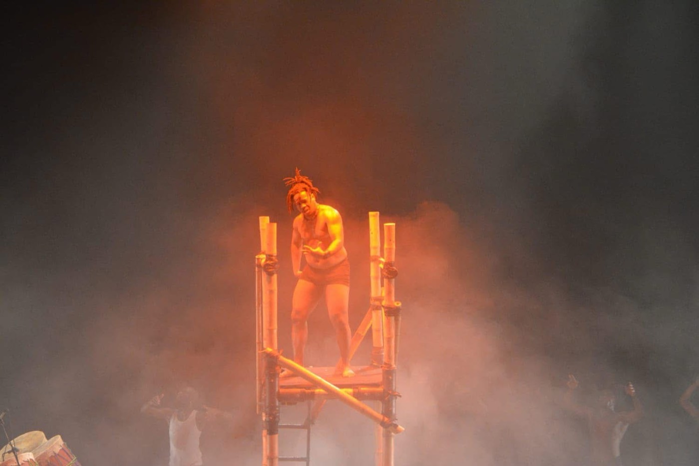 Solo en hauteur sur structure, lumière orangée et fumée